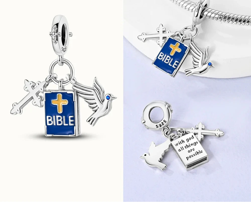 Silver charm with Bible and dove design on a white background, 