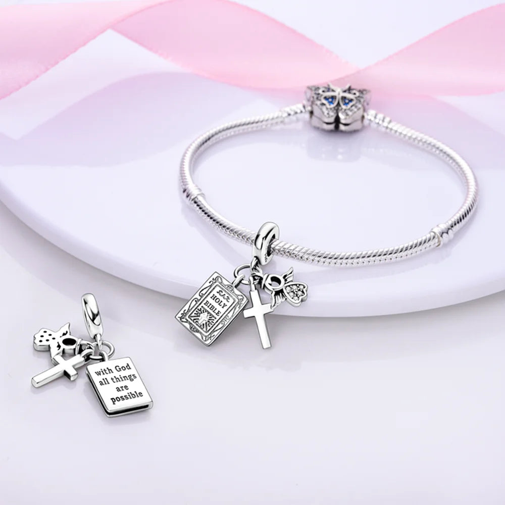 Silver bracelet with various charms on a pink and white striped background