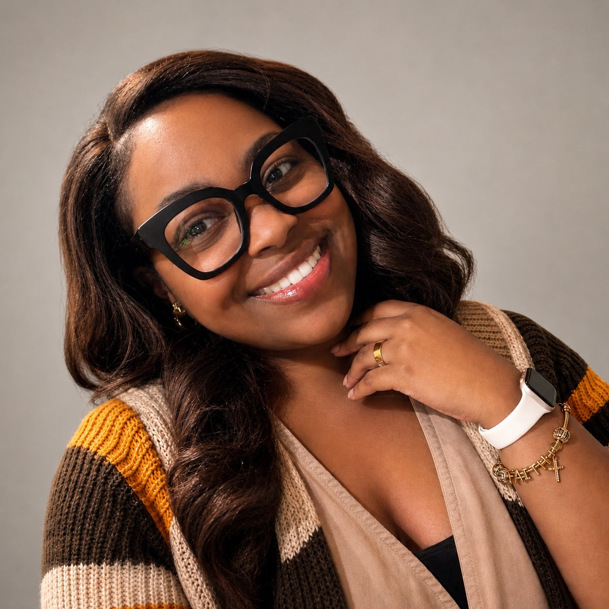 Woman wearing glasses and a striped sweater against a gray background